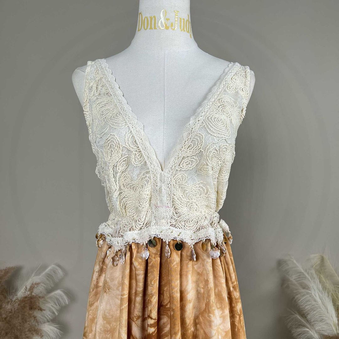 A white crochet deep-V top with an Aura tie-dye skirt is displayed on a mannequin.