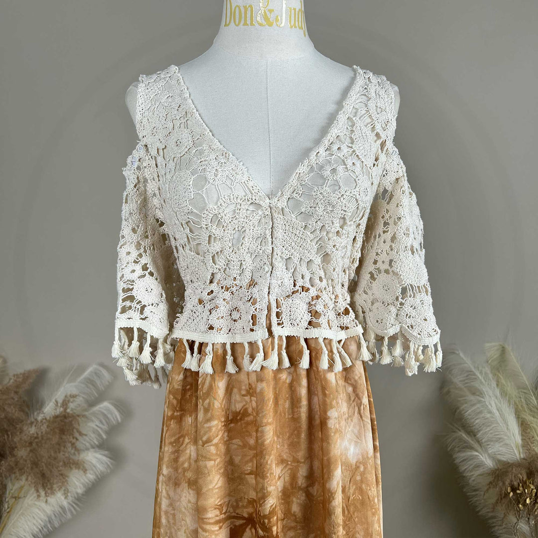 A close up of an Aura white crochet top with a tie-dye skirt.