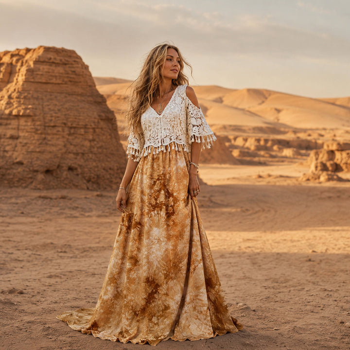 A woman stands in a desert wearing aan Aura tie-dye gown with a crochet top.
