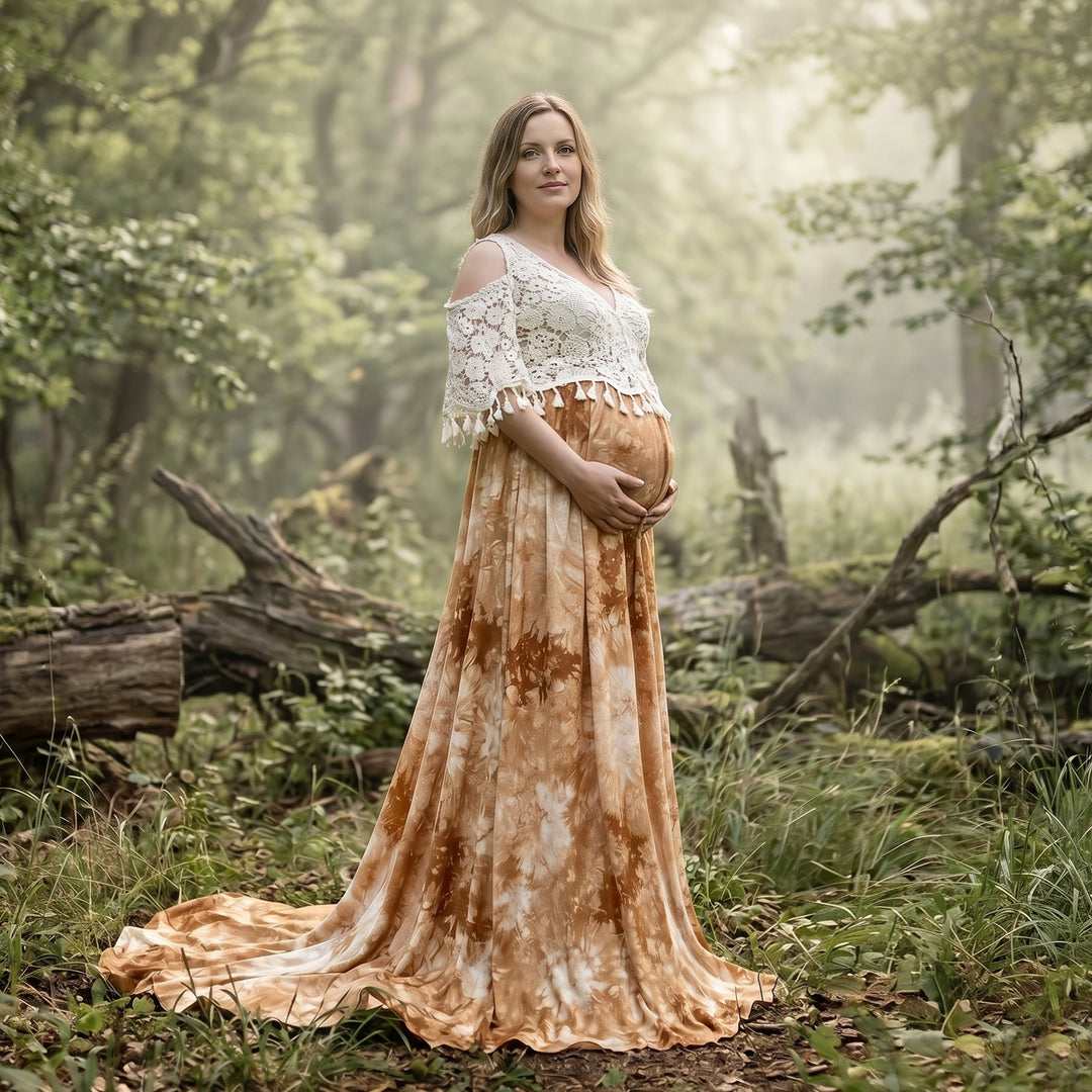 A pregnant woman stands in a woodland wearing an Aura tie-dye gown with a white crochet top.