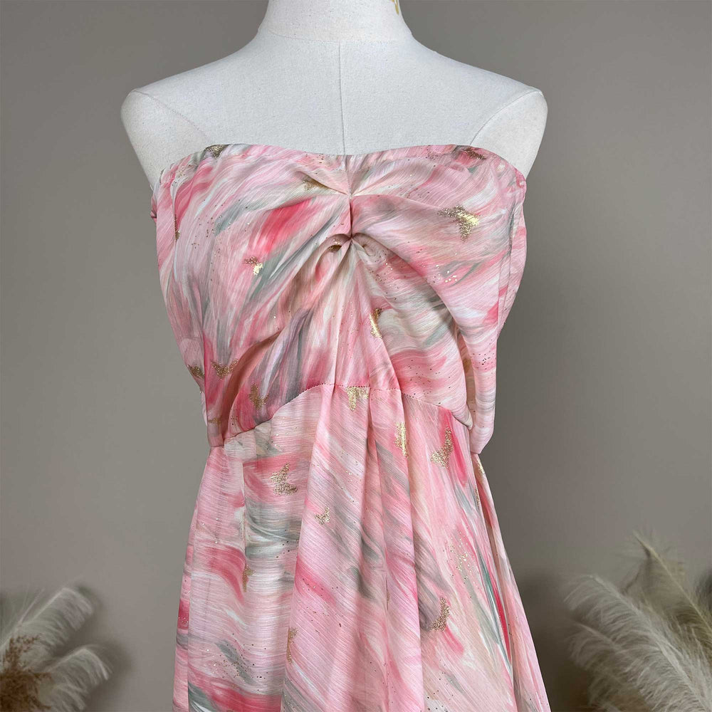 A close up of a Cybele pink printed strapless gown with pleats and a train.