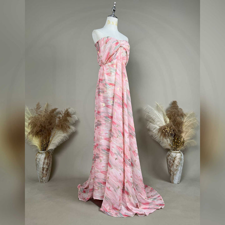A mannequin displays a side view of a Cybele pink printed strapless gown with pleats and a train
