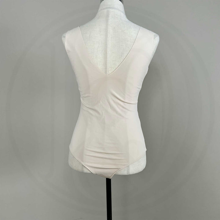 A mannequin shows a back view of a Medusa skin sleeveless bodysuit, revealing the V-neck silhouette and fitted cut; the hem features a curved high-cut design.