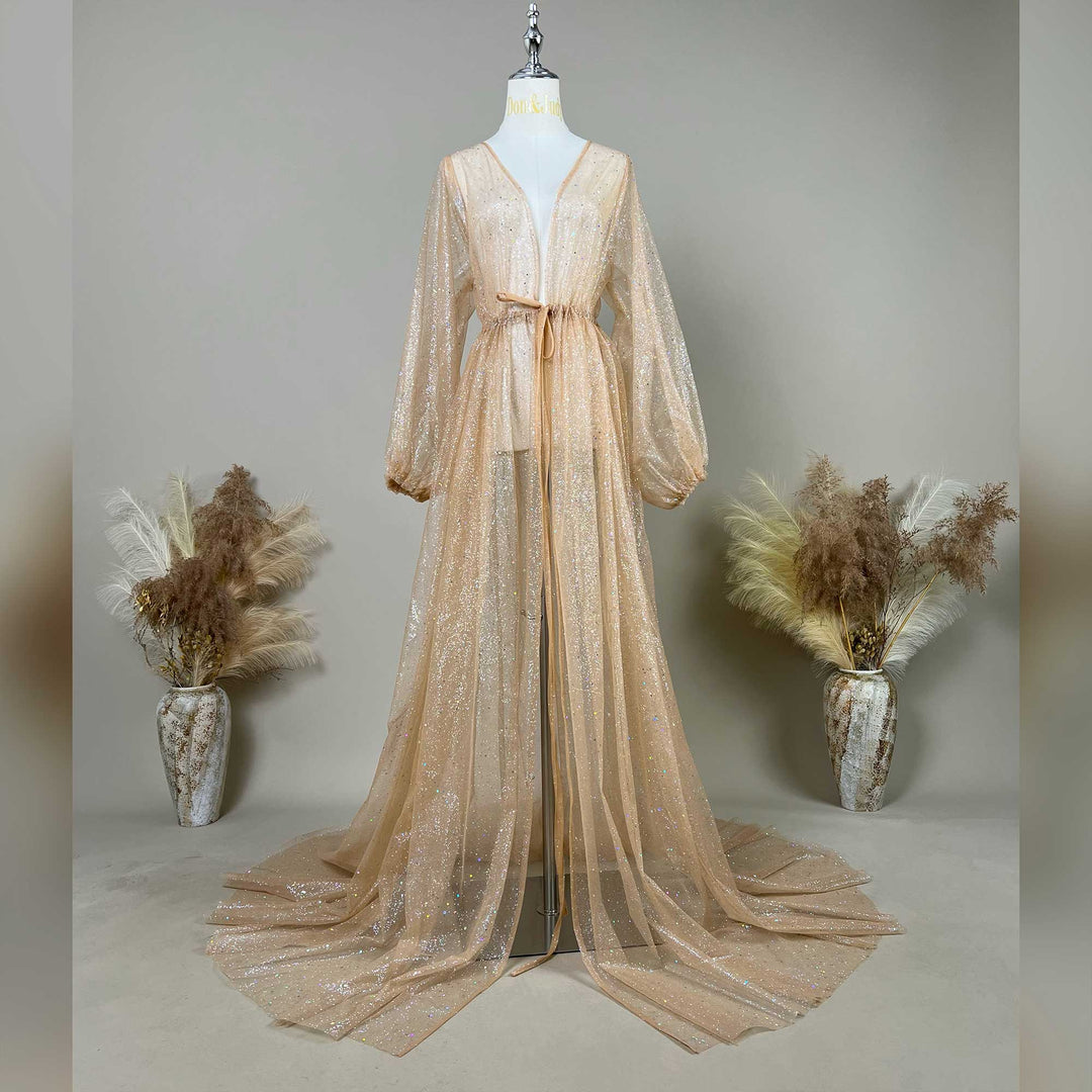 A mannequin displays a Metis khaki sequined V-neck robe with a tie waist and lantern sleeves; the dress features a split train design, set against a solid wall with dried flower vases on both sides.