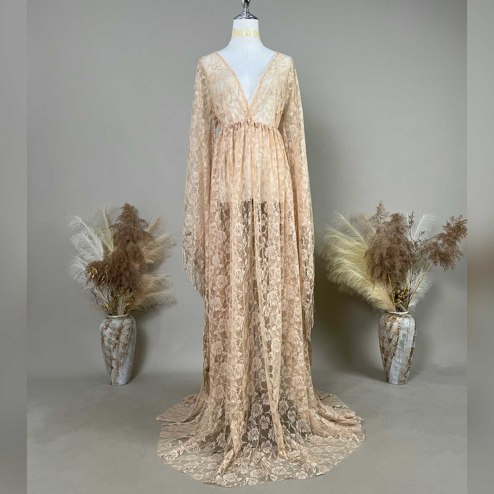 A Pheme  khaki lace V-neck gown is displayed on a mannequin, featuring a ruched high waistline, fringe cuffs, and a floor-sweeping skirt.