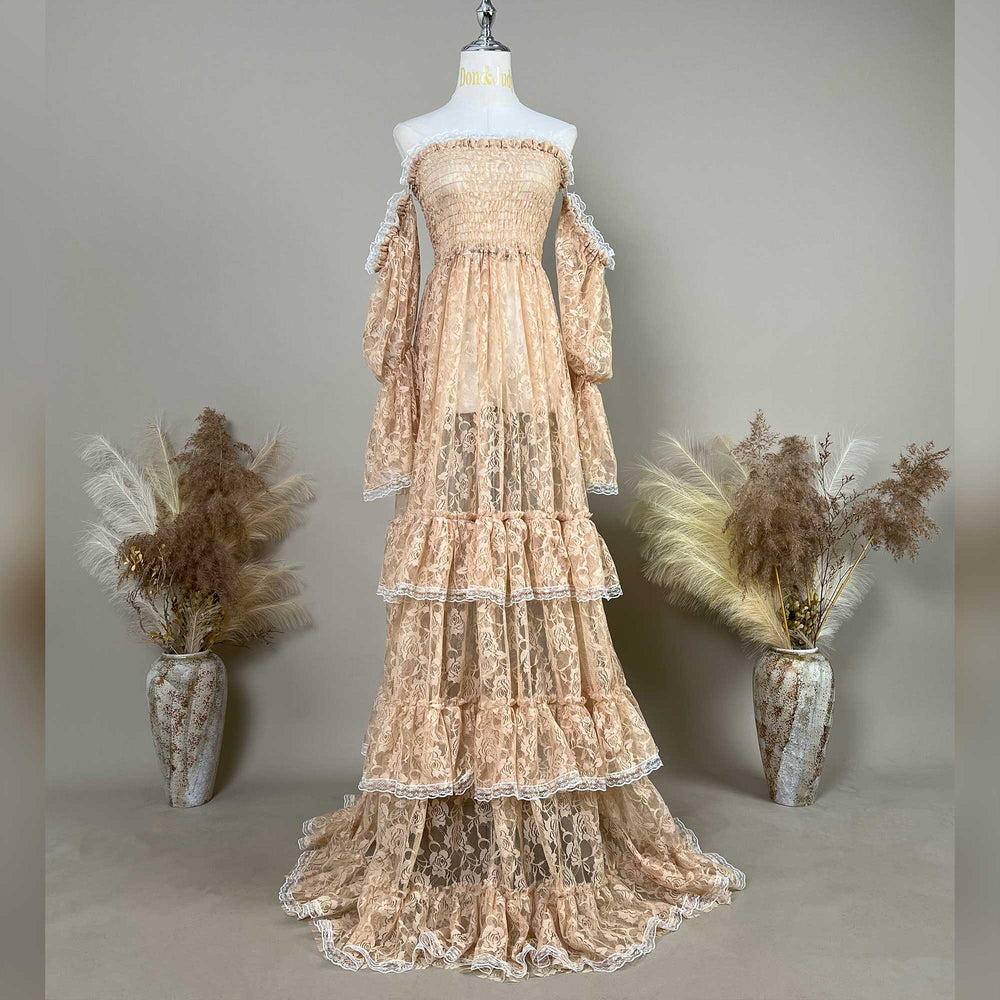 A Selene khaki lace off-shoulder gown is displayed on a mannequin, featuring a shirred bodice, tiered ruffled sleeves, and a multi-layered cake skirt.